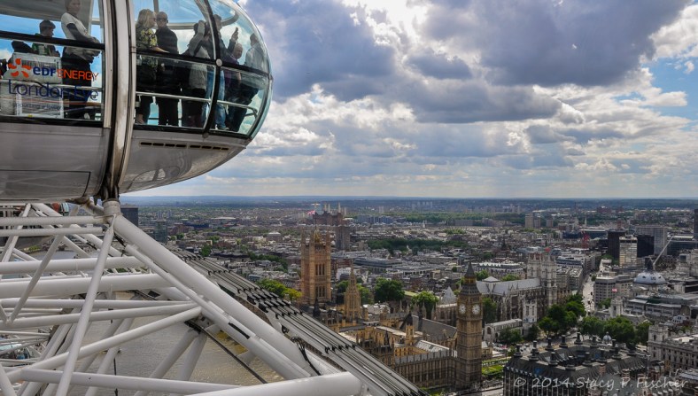  From a capsule atop the London Eye, a view of people in another capsule looking out at the London scene far below.