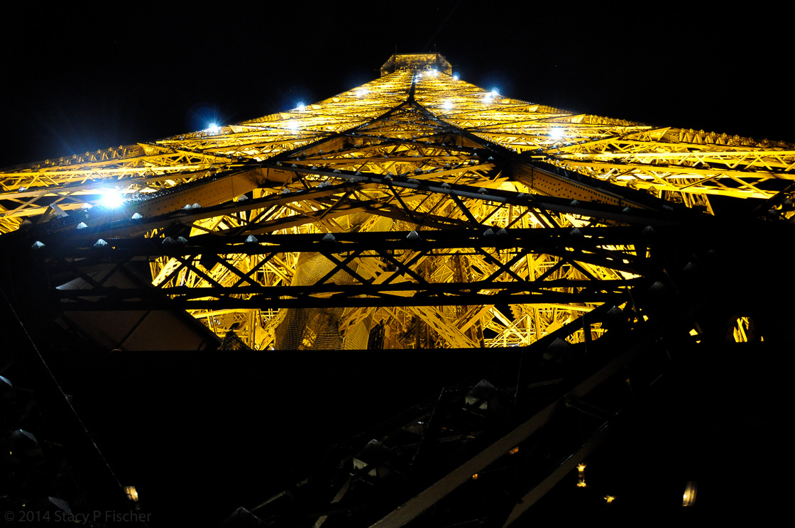 A close-up shot of the top of the Tower from the 2nd floor, with lights twinkling on the golden latticework.