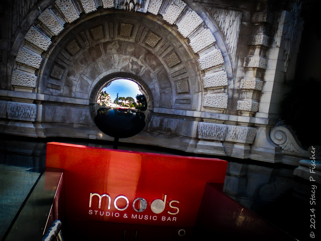A below-ground entrance in red to the Music Bar is capped by a large silver reflective globe.