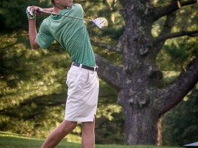 Golfer in final stance after teeing off.