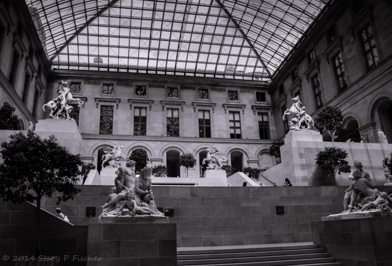 The Cour Marly, topped by a pyramidal glass roof, displays marble statutory.