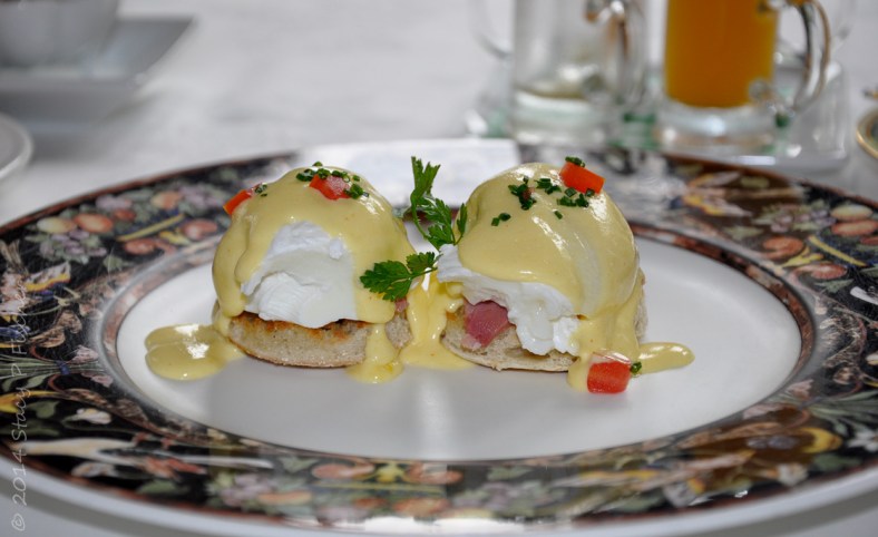Eggs Benedict; Photo: SPFischer Two petite eggs benedict served on a dark floral rimmed white plate.