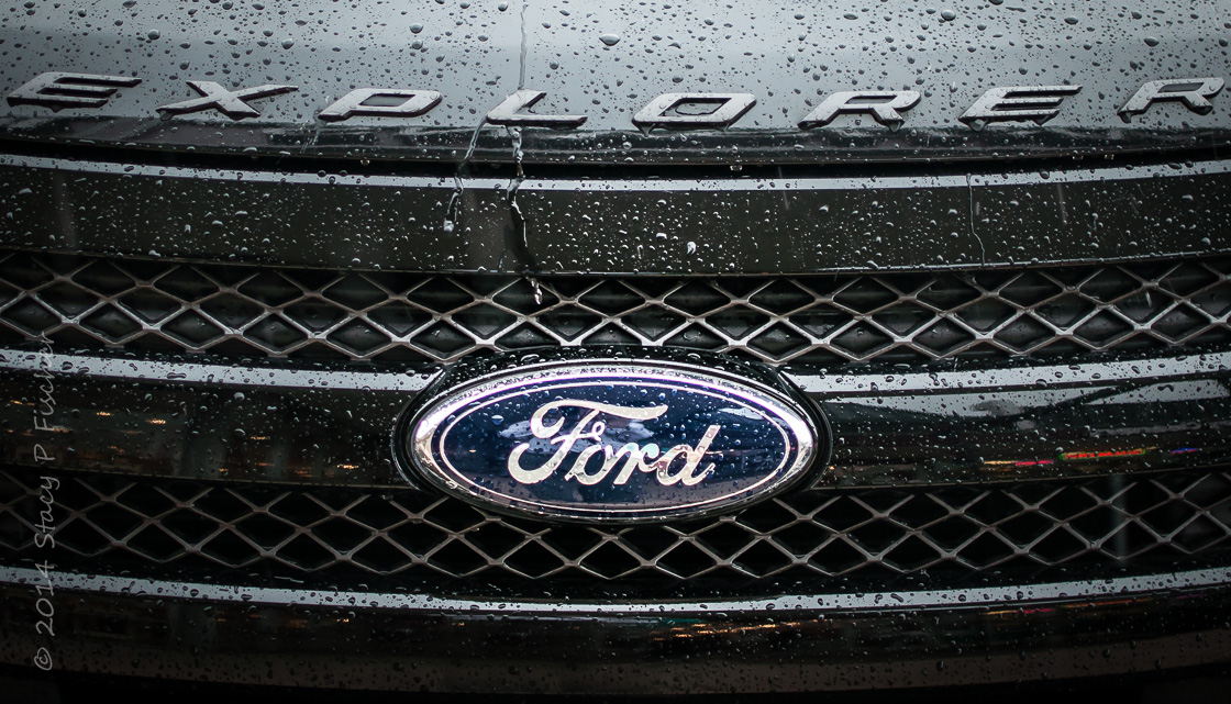 Rainy hood and grill of dark grey Ford Explorer