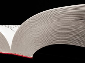 Close-up view of the pages of an opened book, looking from the bottom of the book laid flat.