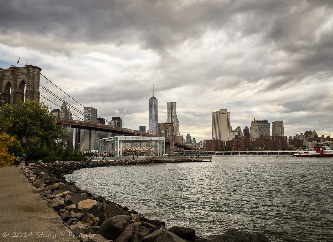 Jane's Carousel in Brooklyn Bridge Park, backdropped by Brooklyn Bridge and One World Trade Center.