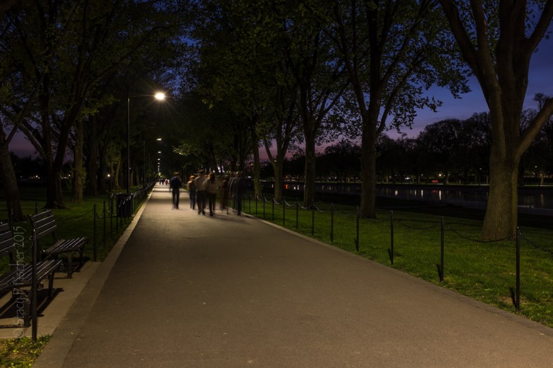 Walkers at night along the path between the World War II and Lincoln Memorials, Washington, D.C.