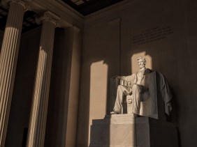 Sunrise illuminates the statue of Lincoln within the Lincoln Memorial