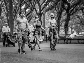 A trio of tattooed pedestrians walking in Central Park