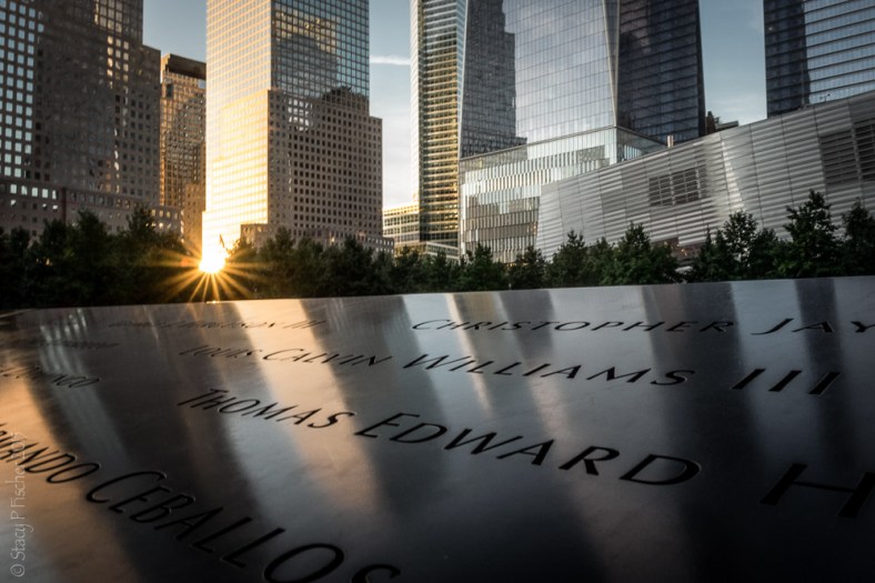 Setting sun cast reflections onto name-inscribed bronze plate of the 9/11 Memorial South Tower reflecting pool.