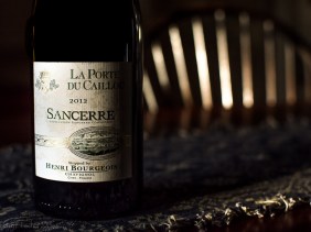 Bottle of Sancerre wine on a table in the shadows of afternoon sun