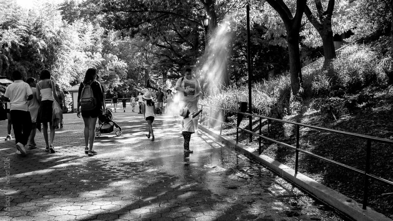 Cooling off in a water mister in a local park