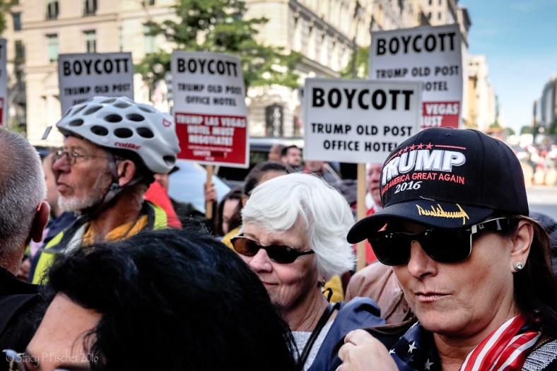 Woman wearing Trump hat in the midst of protestors at Trump International Hotel Washington DC