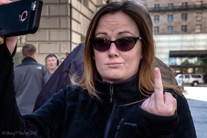 Woman flips the bird protesting Trump at Trump International Hotel Washington DC